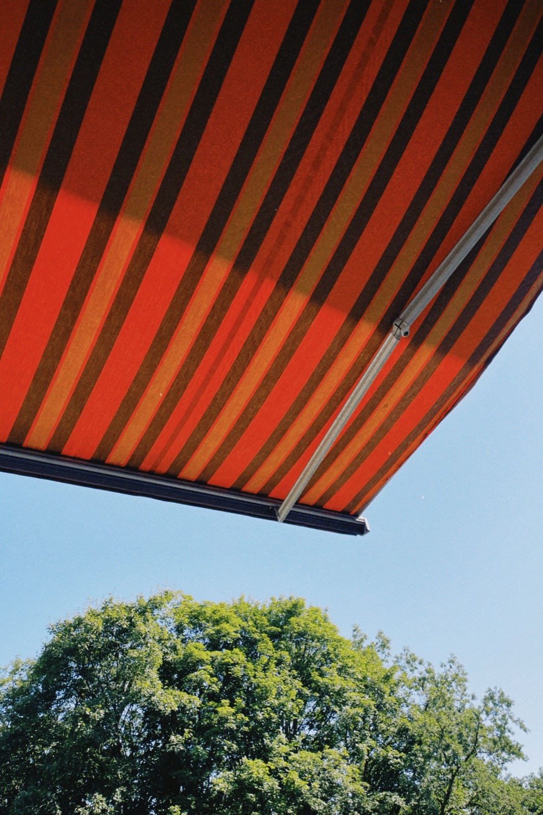 Rot gestreifte Markise vor blauem Himmel